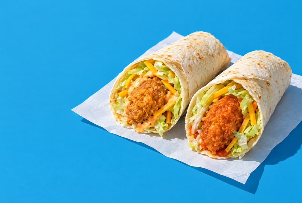 Two small crispy chicken wraps with lettuce and cheese